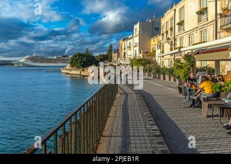 Sonnenuntergang über den Häusern entlang der Küste von Alfeo in Ortigia, dem ältesten Teil der Stadt Syrakus. Syrakus, Sizilien, Italien, Europa Stockfoto