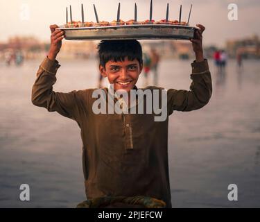 Karatschi Pakistan 2019, ein kleiner Junge, der Chaat in einem Stahlthal am Sea View karatschi früh am Morgen verkauft. Stockfoto