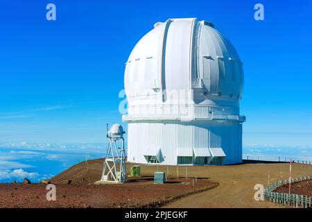 Observatoriumseinheit auf dem Gipfel von Mauna Kea, vor einem klaren blauen Himmel. Stockfoto