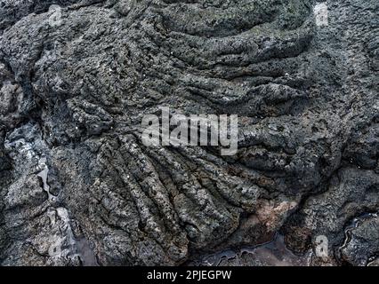 Abstrakter Naturhintergrund: Gehärteter Lavafelsen an der Meeresküste Hawaiis. Stockfoto