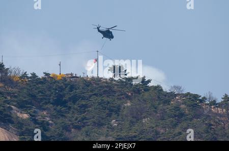 Seoul, Südkorea. 02. April 2023. (230402) -- SEOUL, 2. April 2023 (Xinhua) -- Ein Hubschrauber versucht, einen Waldbrand auf Mount Inwang in Seoul, Südkorea, zu löschen, 2. April 2023. Ein relativ großer Brand ereignete sich um 11:53 Uhr Ortszeit (0253 Uhr MEZ) auf dem Berg Inwang in Seoul, einem Berg in der Nähe des vorherigen Präsidentenamts des Landes. Die Feuerwehrbehörden hatten über drei Stunden lang versucht, ihn unter Kontrolle zu bringen, indem sie Hunderte von Beamten, neun Hubschrauber und andere Ausrüstung mobilisierten. Es wurden noch keine Opfer gemeldet, aber Bewohner von etwa 120 Haushalten waren evakuiert worden Stockfoto