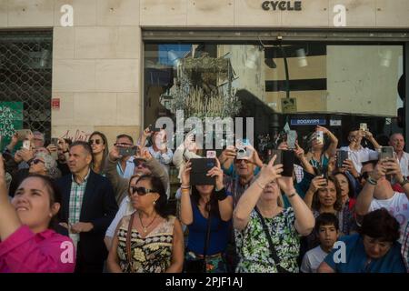 Malaga, Spanien. 02. April 2023. Der Thron der Bruderschaft „Pollinica“ mit einer Statue der Jungfrau Maria wird auf einem Fenster reflektiert, während die Menschen die Prozession während der Feierlichkeiten der Heiligen Woche beobachten. Tausende von Menschen feiern die Heilige Woche und warten darauf, die Bruderschaften und Osterprozessionen auf den Straßen der Stadt zu sehen. Die Heilige Woche in Andalusien, die Tausende von Gläubigen und Gläubigen zusammenbringt, gilt als eine der wichtigsten religiösen und kulturellen Feierlichkeiten in der Region. Kredit: SOPA Images Limited/Alamy Live News Stockfoto