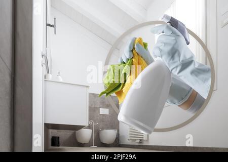 Reinigungsservice und -Produkte. Hände mit Handschuhen, Lappen und Sprühflasche isoliert auf sauberem Badezimmerhintergrund, kontaktiert Housekeeping-Firma. Werbung Stockfoto