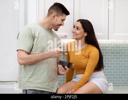 Hübscher junger Mann, der sich um seine hübsche Freundin kümmert Stockfoto