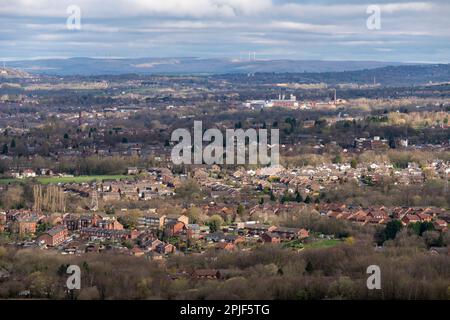 Blick über die Stadt Hyde im Großraum Manchester, England, mit Windturbinen auf den Mooren in der Ferne. Stockfoto