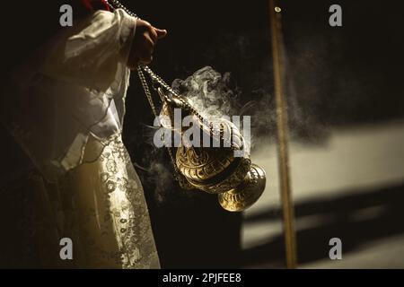 Barcelona, Spanien. 2. April 2023. Ein Gefolgsmann aus der Bruderschaft 'Gran Poder und Macarena Esperanza' wandelt während der Palm Sunday Prozession in Barcelona auf der Straße mit Weihrauch. Kredit: Matthias Oesterle/Alamy Live News Stockfoto
