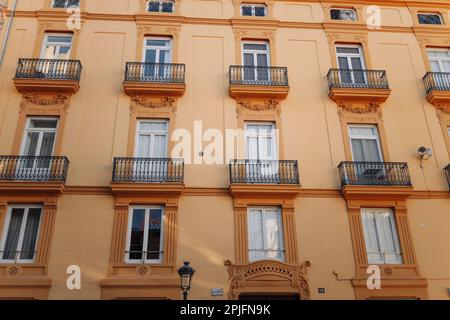 Fenster mit Fensterläden und kleinen Balkonen auf der Außenfassade des Gebäudes in der Innenstadt von Barcelona, Spanien Stockfoto