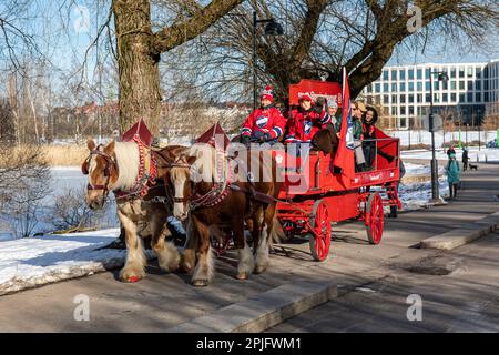 Jütland zieht Pferde, die einen Wagen voller Menschen ziehen und für die Brauerei Sinebrychoff im Hesperia Park, Helsinki, Finnland werben Stockfoto