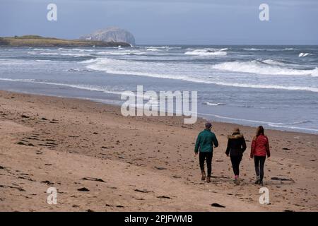 Dunbar, Schottland, Großbritannien. 2. April 2023 Menschen, die das sonnige, aber trügerisch kalte Wetter entlang der östlichen Lothian Küste in Belhaven Bay genießen. Temperatur um 5C Grad in der Brise. Blick über die vierte Mündung in Richtung Bass Rock. Strandspaziergänge. Kredit: Craig Brown/Alamy Live News Stockfoto