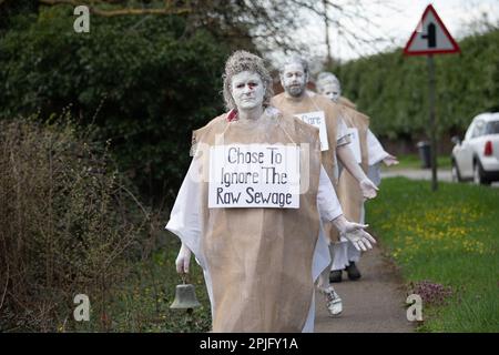 Little Marlow, Buckinghamshire, Großbritannien. XR Penitents hat heute in Buckinghamshire vor der Themse gegen das Wasser der Themse protestiert und gegen die Abwasserentsorgung der Themse protestiert. Die Geisterfiguren der Penitents gingen von den Abwasserwerken zur Themse und trugen Sündenplakate, um die Öffentlichkeit für Abwasserableitungen zu sensibilisieren. Umweltministerin Thérèse Coffey hat angekündigt, dass Wasserunternehmen unbegrenzte Geldstrafen für verschmutzende Flüsse erhalten werden, doch viele Umweltschützer sind der Meinung, dass dies nicht weit genug geht und dass der Rückzug erfolgt Stockfoto