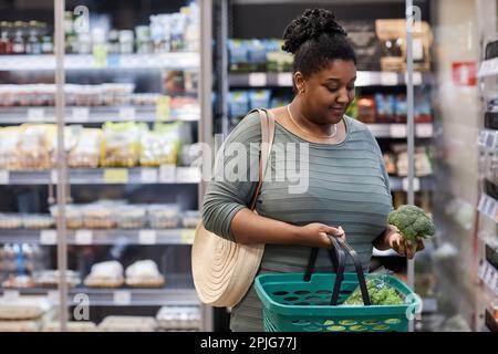 Porträt einer echten schwarzen Frau, die frisches Gemüse im Supermarkt kauft, Kopierraum Stockfoto