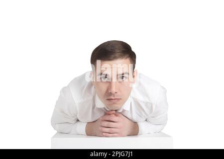 Ein Mann in einem weißen Hemd sieht mit überraschten Augen aus Stockfoto