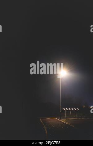 Hinterlandschild, beleuchtet durch eine einzelne Lampe am Abend im Winter Stockfoto
