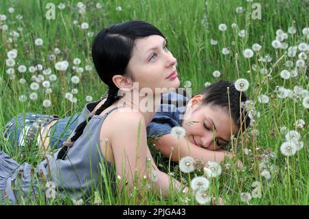 Zwei junge, schöne Frauen in stiller Kommunikation auf der Frühlingswiese Stockfoto