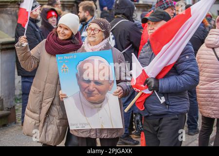 Danzig, Polen, April 2. 2023 mehrere hundert Menschen mit Porträts von Johannes Paul II. Und Flaggen des Vatikans gingen in das sogenannte. Papstmarsch zur Verteidigung von Papst Johannes Paul II. Am 2. April 2023 in Danzig, Polen. Die Teilnehmer des marsches sind hauptsächlich Rentner und ältere Menschen, inspiriert von katholischen Priestern und Politikern der herrschenden rechtsgerichteten Koalition. Der marsch wurde nach einem hochrangigen TVN-Bericht organisiert, der enthüllte, dass der Papst über Pädophilie in der katholischen Kirche Bescheid wusste und aktiv dazu beitrug, sie zu verbergen, einschließlich der Überstellung von Priestern, die der Pädophilie verdächtigt werden, in andere Gemeinden. Cre Stockfoto