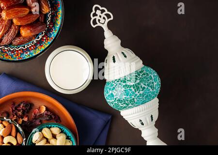Ramadan Kareem – Speisen und Getränke. Datteln Sie Früchte, Nüsse und Milch auf dunklem Hintergrund. Das Ramadan-Karäm-Fasting-Monatskonzept. Draufsicht Stockfoto