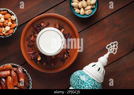 Ramadan Kareem und iftar muslimisches Essen. Entsteinte Datteln, Nüsse und Milch auf Holzbrettern. Traditionelles iftar-Essen Stockfoto