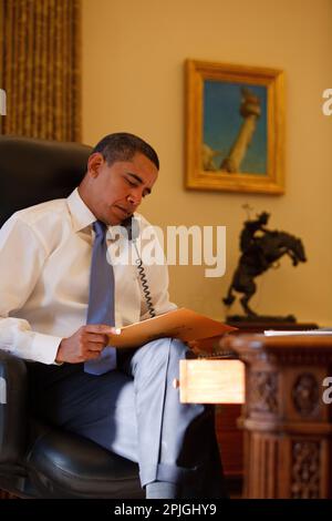 Präsident Barack Obama liest den Brief im Oval Office Resolute Desk für ihn am Tag zuvor, die der ehemalige Präsident George W. Bush. Das Schreiben des früheren Präsidenten, der künftige Präsident hat einen Weißen Haus Tradition geworden. 1/21/09. Offizielle Weiße Haus Foto von Pete Souza Stockfoto