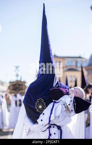 Sevilla, Spanien. 2. April 2023. Ein Bußgesicht (nazareno) der Bruderschaft namens „La Estrella“ trägt ein Baby während seiner Parade zur Kathedrale von Sevilla am Palmsonntag, „Domingo de Ramos“ auf Spanisch (Kreditbild: © Daniel Gonzalez Acuna/ZUMA Press Wire) NUR REDAKTIONELLE VERWENDUNG! Nicht für den kommerziellen GEBRAUCH! Stockfoto