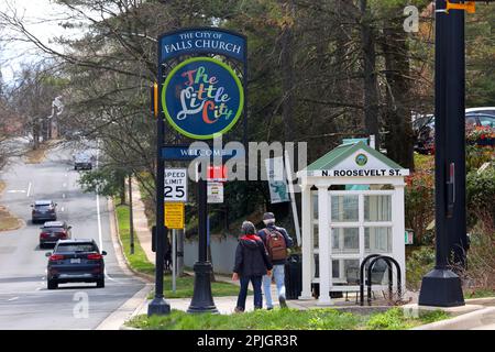 Zwei ältere Personen gehen am Willkommensschild der City of Falls Church auf der N Roosevelt Street vorbei Stockfoto