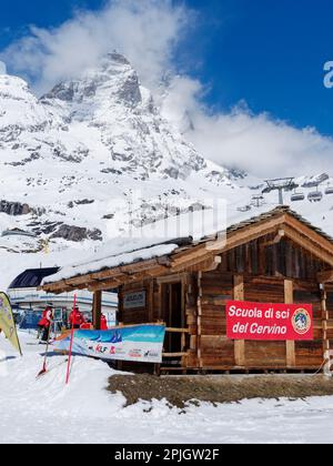 Skischule im Ferienort Breuil-Cervinia im Aosta-Tal, Italien, mit einem Sessellift und dem schneebedeckten Cervino-Berg, auch bekannt als Matterhorn, dahinter. Stockfoto