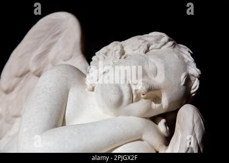 MAILAND, ITALIEN - CA. AUGUST 2020: Niedlicher schlafender Engel. Statue aus Marmor, Ende des 18th. Jahrhunderts, unbekannter Bildhauer. Konzept für Schlaf, Unschuld und Stockfoto
