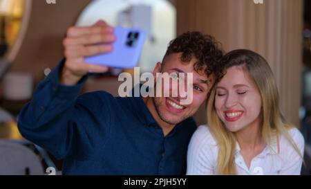 Glückliches junges Paar, das Selfie machte, während es im Café saß. Mann macht Foto, Frau isst. Liebe, Dating, Essen, Lifestyle-Konzept Stockfoto