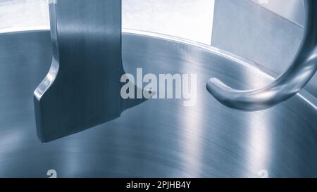 Industrieller, offener Lebensmittelmischer mit Messern in der Lebensmittelindustrie aus Nahaufnahme. Industrieller offener Mischer für Nahaufnahmen in der Lebensmittelindustrie Stockfoto