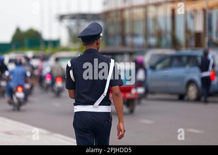Phnom Penh, Kambodscha - August 26 2018: Polizist reguliert den Verkehr gegenüber dem Hotel-Casino "Nagaworld". Stockfoto