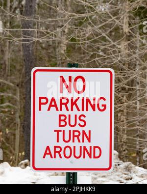 Ein rot-weißes Schild für „kein Parkplatz“, der Bus dreht am Ende einer Straße in Speculator, NY USA, im Wald um Stockfoto