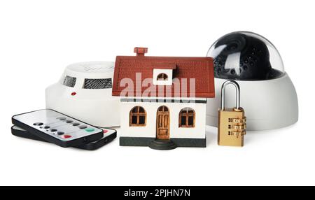 Hausmodell, CCTV-Kamera, Fernbedienungen, Schloss und Rauchmelder auf weißem Hintergrund. Heim-Sicherheitssystem Stockfoto