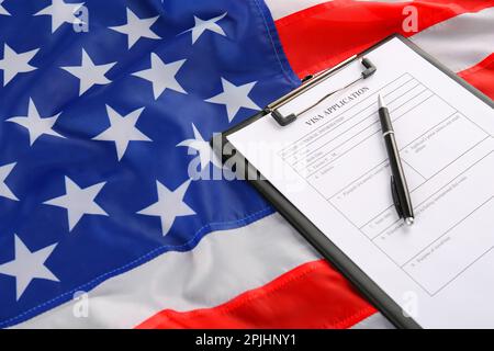 Visumantrag und Stift auf amerikanischer Flagge. Einwanderung in die USA Stockfoto