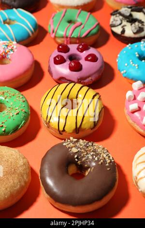 Süße, leckere glasierte Donuts auf Korallenhintergrund Stockfoto