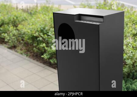 Grauer Mülleimer im Park, Schließung. Platz für Text Stockfoto