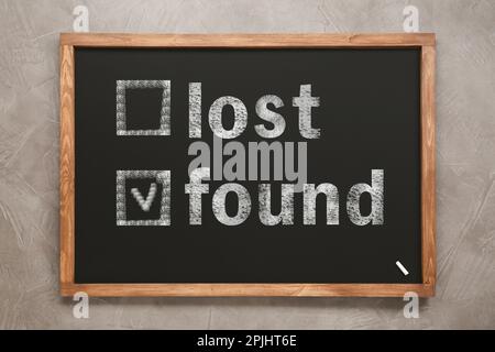 „Lost and Found“-Schriftzug auf grauem Hintergrund, Draufsicht Stockfoto