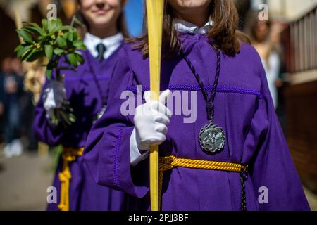 Mädchen in lila Bademänteln halten während der Passage der Ananda Bouquets mit dem Bild von Jesus auf dem Esel, während der Prozession „La Borriquilla“ durch die Straßen von Sahagún. Die Prozession der Palmen stellt den Übergang Jesu zu seinem triumphalen Eintritt nach Jerusalem dar. Die Prozession führte durch die Straßen der Stadt, begleitet von Gläubigen mit Bouquets und der Symphonic-Band der Stadt. (Foto: Luis Soto/SOPA Images/Sipa USA) Guthaben: SIPA USA/Alamy Live News Stockfoto