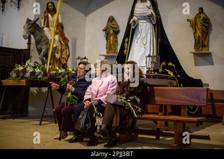 Frauen mit Blumensträußen in den Händen bleiben während der Messe in der Kirche San Lorenzo sitzen, nachdem sie die Durchfahrt der Ananda mit dem Bild Jesu auf dem Esel beendet haben, während der Prozession „La Borriquilla“ durch die Straßen von Sahagún. Die Prozession der Palmen stellt den Übergang Jesu zu seinem triumphalen Eintritt nach Jerusalem dar. Die Prozession führte durch die Straßen der Stadt, begleitet von Gläubigen mit Bouquets und der Symphonic-Band der Stadt. (Foto: Luis Soto/SOPA Images/Sipa USA) Guthaben: SIPA USA/Alamy Live News Stockfoto