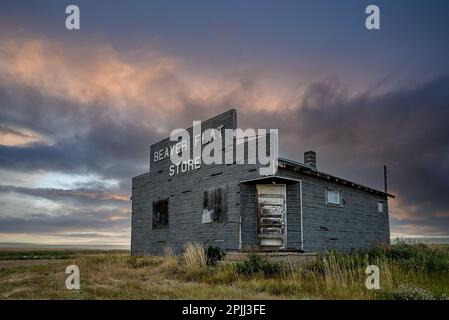 Beaver Flat, SK, Kanada- 16. Juli 2021: Stürmischer Himmel über dem verlassenen Beaver Flat General Store in der Nähe von Swift Current, Saskatchewan Stockfoto