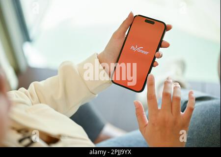 Chiang Mai, Thailand - März 31 2023: Eine Frau, die die Payoneer-Anwendung auf ihrem Smartphone verwendet. IPhone mit Payoneer Logo-App auf dem Bildschirm Stockfoto