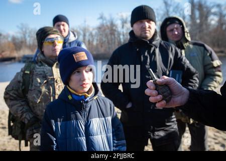 Kiew, Ukraine. 13. Februar 2022. Ein territorialer Verteidigungskämpfer demonstriert bei einer Übung für Zivilisten eine Handgranate, die an einem städtischen Strand in Kiew trainiert wird, während eine russische Invasion der Ukraine droht. (Foto: James McGill/SOPA Images/Sipa USA) Guthaben: SIPA USA/Alamy Live News Stockfoto