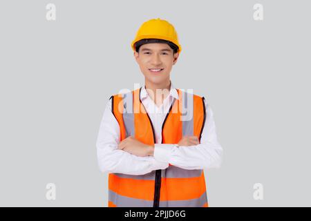 Porträtingenieur junger asiatischer Mann mit Helm steht und lächelt selbstbewusst isoliert auf weißem Hintergrund, gutaussehender Mann ist Architekt oder Redner Stockfoto