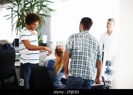 Ich habe das Dokument, um das Sie gebeten haben. Eine Gruppe von Kollegen, die zusammen im Büro arbeiten. Stockfoto