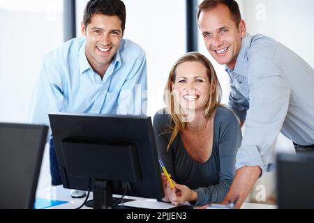 Goldene Regel bei der Arbeit die Chefswitze sind immer lustig. Drei lächelnde Arbeiter, die in ihrem Büro zufrieden aussahen. Stockfoto