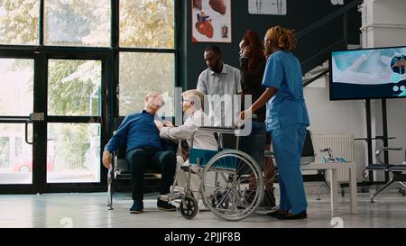 afroamerikanische Menschen helfen dem alten Mann bei der Check-up-Konsultation, bringen kranken Patienten mit Herzproblemen in die medizinische Einrichtung. Arzt, der eine Person mit Sodbrennen untersucht. Stockfoto