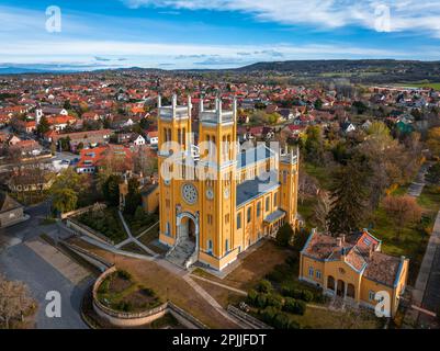 FOT, Ungarn - Luftaufnahme der römisch-katholischen Kirche der Unbefleckten Empfängnis (Szeplotlen Fogantatas Templom) in der Stadt FOT auf einem sonnigen Sort Stockfoto