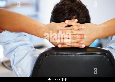 Um deinen Verstand zu befreien, musst du einen Schritt zurücktreten. Rückansicht eines jungen Mannes, der sich mit den Händen hinter dem Kopf entspannt. Stockfoto