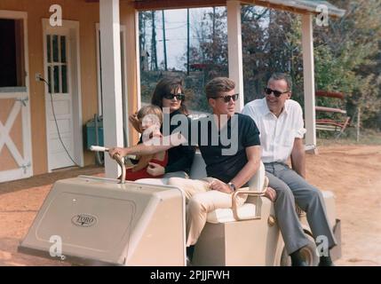 ST-C369-12-63 27. Oktober 1963 Wochenende in Atoka: President und Mrs. Kennedy, John F. Kennedy Jr., (JFK, Jr.) und K. LeMoyne „Lem“ Billings fahren im Golfwagen [Leichte Kratzer auf der rechten Seite des Negativen.] Bitte schreiben Sie 'Cecil Stoughton. Fotos Vom Weißen Haus. John F. Kennedy Presidential Library and Museum, Boston“ Stockfoto