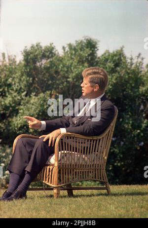 ST-C276-8-63 2. September 1963 Präsident John F. Kennedy saß in einem Korbstuhl im Freien auf einem Rasen, während er von Walter Cronkite interviewt wurde. Squaw Island, Hyannis Port, Massachusetts. Bitte schreiben Sie 'Cecil Stoughton. Fotos Vom Weißen Haus. John F. Kennedy Presidential Library and Museum, Boston“ Stockfoto