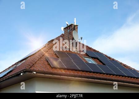 Haus mit installierten Sonnenkollektoren auf dem Dach. Alternative Energie Stockfoto