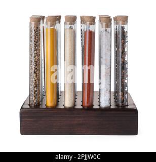 Glasröhrchen mit unterschiedlichen Gewürzen im Rack auf weißem Hintergrund Stockfoto